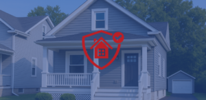 Gray single-family Toledo rental home with a red shield-and-house protection icon overlay, symbolizing investment and insurance coverage.