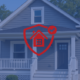 Gray single-family Toledo rental home with a red shield-and-house protection icon overlay, symbolizing investment and insurance coverage.
