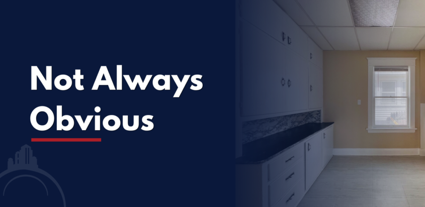 Older rental property kitchen interior with a dark navy overlay and text reading “Not Always Obvious,” used for a blog about recognizing signs of lead paint exposure.
