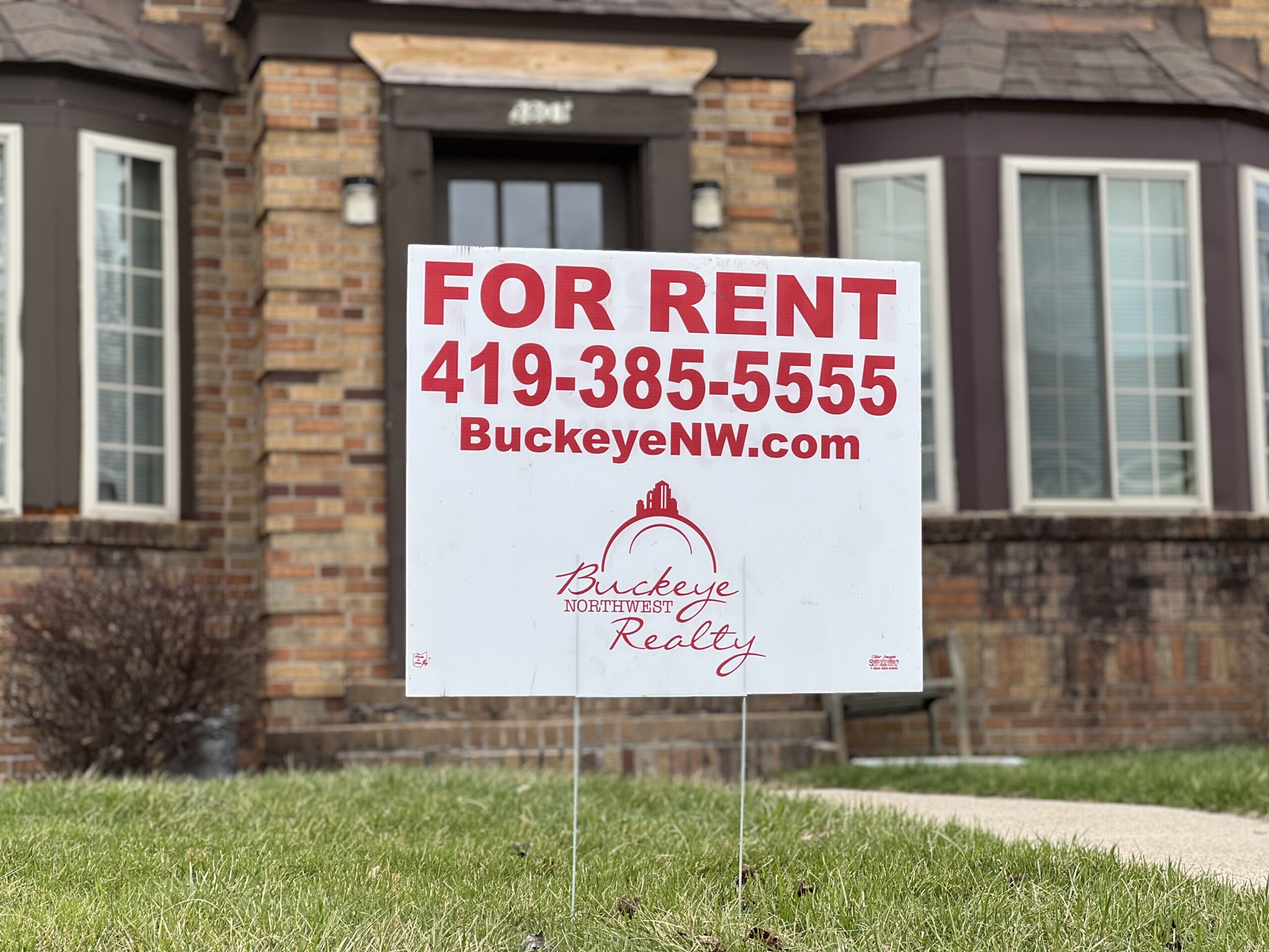 Buckeye Northwest Realty for rent sign in front of a rental property
