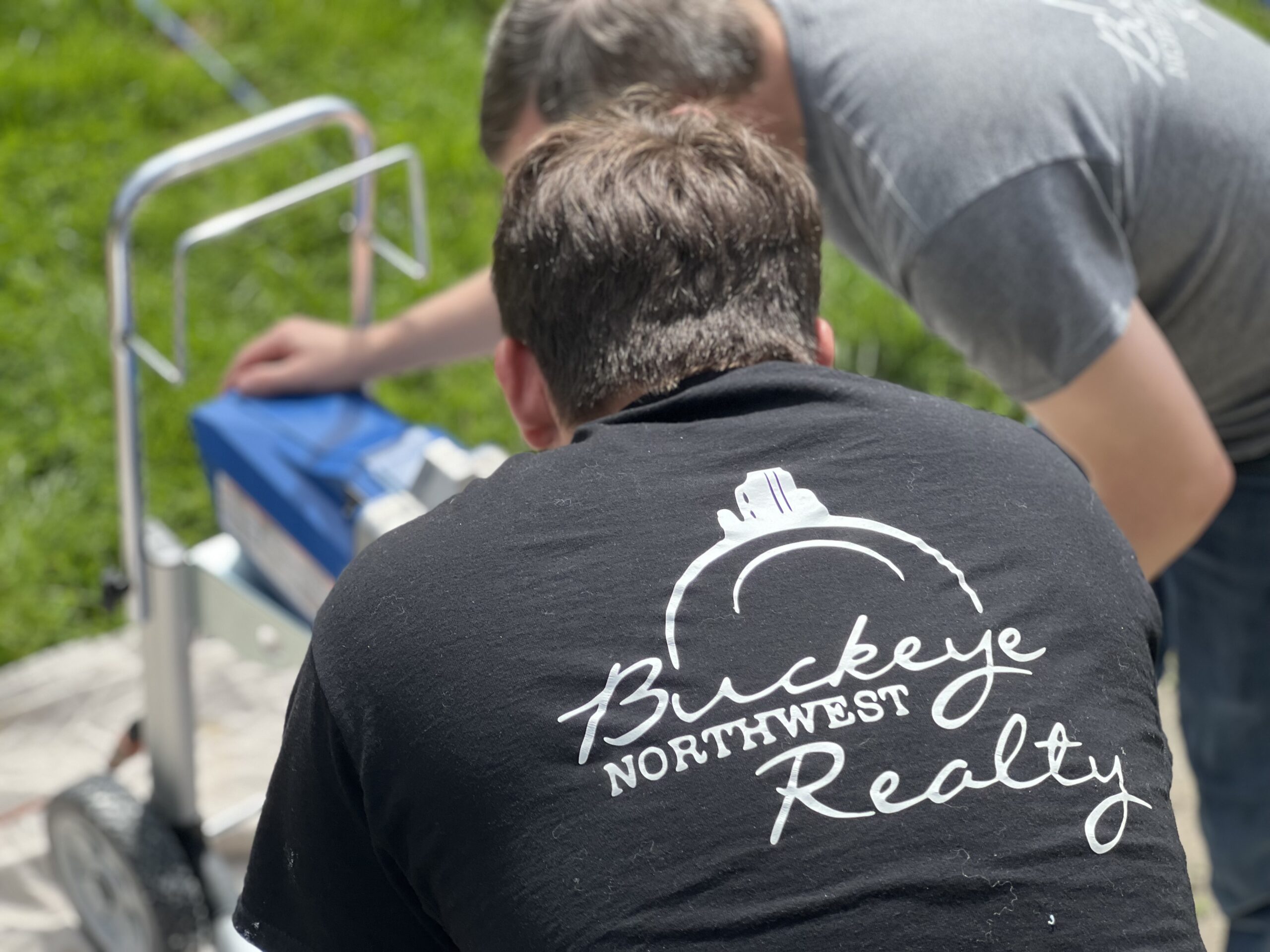 Buckeye Northwest Realty team member wearing a company shirt while working outdoors at a rental property in Toledo, Ohio