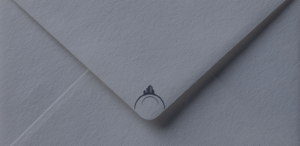 Close-up of a navy envelope with a subtle Buckeye Northwest Realty logo, representing updating your mailing address when moving.